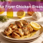 Air Fryer Chicken Breast on plate with golden chicken pieces lemon balsamic glaze