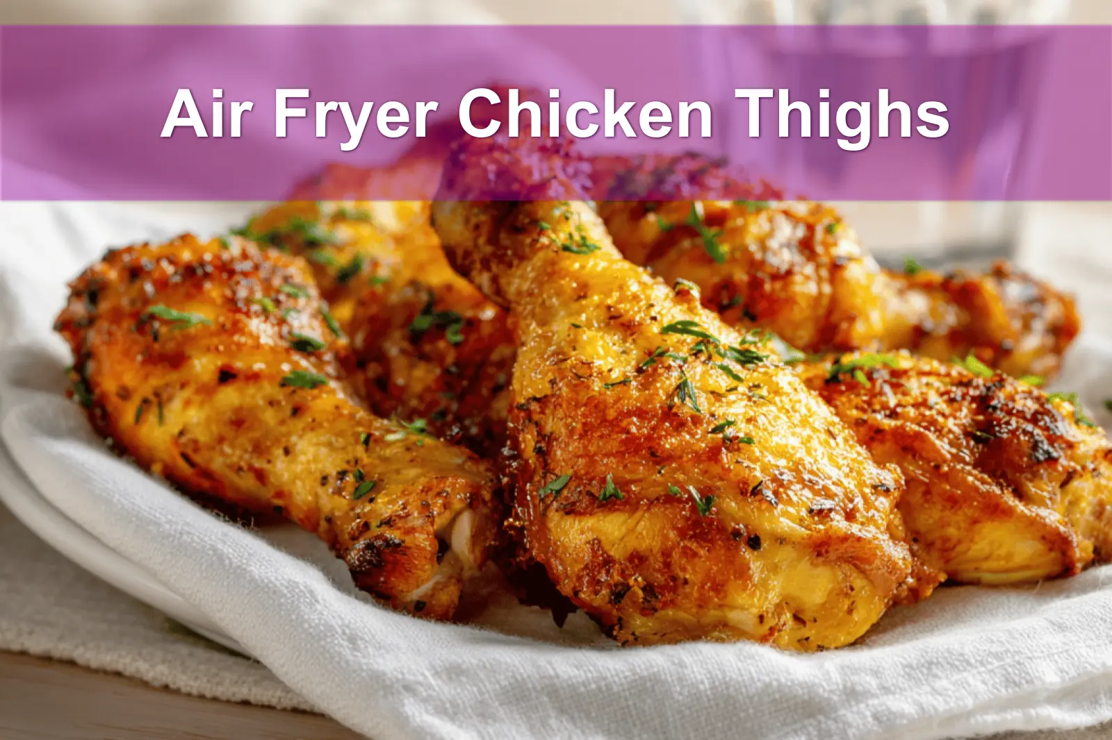 Air Fryer Chicken Thighs golden crisp skin served on white cloth with glass of water