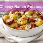 Cheesy Ranch Potatoes and Smoked Sausage for Easy Dinners 5 Cheesy Ranch Potatoes served with smoked sausage on white napkin, garnished with melted cheese and herbs.