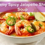 Creamy Spicy Jalapeño Shrimp Soup in a warm bowl garnished with lime and fresh green herbs