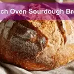 Dutch Oven Sourdough Bread presented on white cloth with clear glass of water beside it