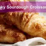 Flaky Sourdough Croissants: Perfect Homemade Layers Every Time 5 Flaky Sourdough Croissants on white napkin with water, clean and warm setup