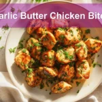 Garlic Butter Chicken Bites plated beautifully, garnished with parsley, and paired with a clear water glass