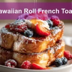 Hawaiian Roll French Toast plated with berries powdered sugar maple syrup on white cloth napkin