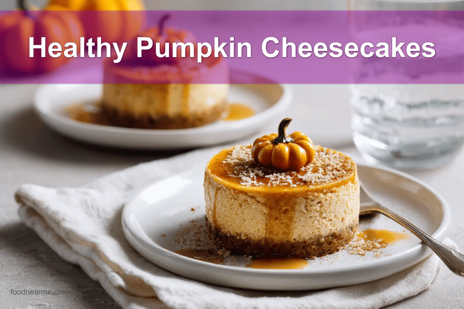 Healthy Pumpkin Cheesecakes styled on a white napkin with water glass in warm lighting