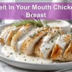 Melt In Your Mouth Chicken Breast plated with creamy white sauce and grated hard cheese warm lighting