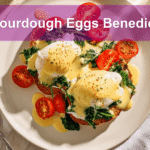 Sourdough Eggs Benedict Spinach Florentine on plate with hollandaise and tomato slices