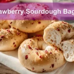 Strawberry Sourdough Bagels on white napkin with water glass beside them