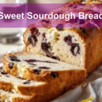 Sweet Sourdough Bread with golden crust, blueberries, and cheese on a white cloth napkin.