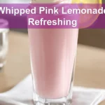 Whipped Pink Lemonade Refreshing Recipe in a clear glass, lightly styled with a raspberry garnish.