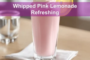 Whipped Pink Lemonade Refreshing Recipe in a clear glass, lightly styled with a raspberry garnish.