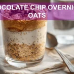 CHOCOLATE CHIP OVERNIGHT OATS creamy jar topped with vegan chips in warm natural light