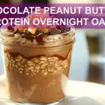 CHOCOLATE PEANUT BUTTER PROTEIN OVERNIGHT OATS in jar with peanut butter drizzle and chocolate chips