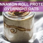 CINNAMON ROLL PROTEIN OVERNIGHT OATS jar with cinnamon swirl on white napkin beside water