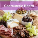 Charcuterie Board with brie prosciutto grapes figs crackers on warm styled table