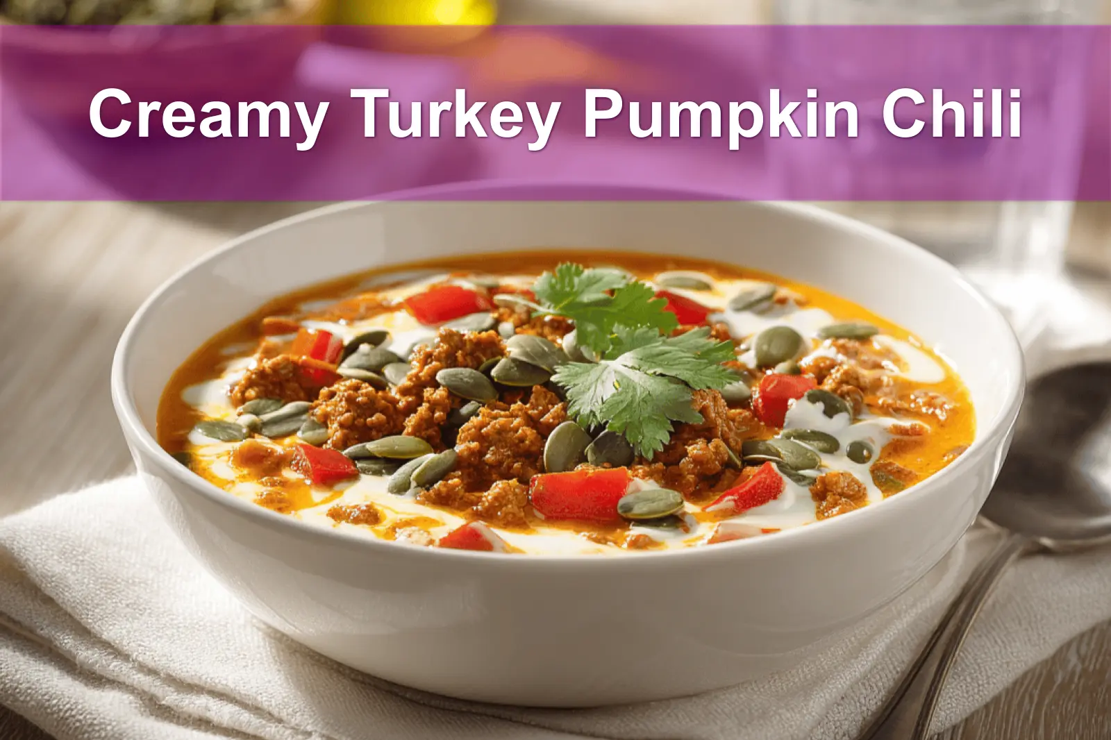 Creamy Turkey Pumpkin Chili in bowl on white napkin with glass of water