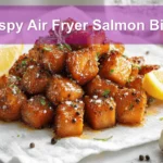 Crispy Air Fryer Salmon Bites golden cubes with lemon and herbs on white napkin