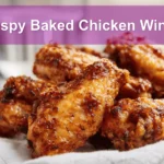 Crispy Baked Chicken Wings on white napkin with clear water glass warm natural light