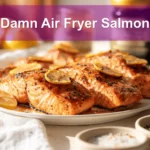 Damn Air Fryer Salmon plated with lemon slices honey soy glaze olive oil bottle beside glass