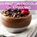 HIGH PROTEIN CHOCOLATE CHIA PUDDING in a jar topped with berries cacao nibs and coconut whip