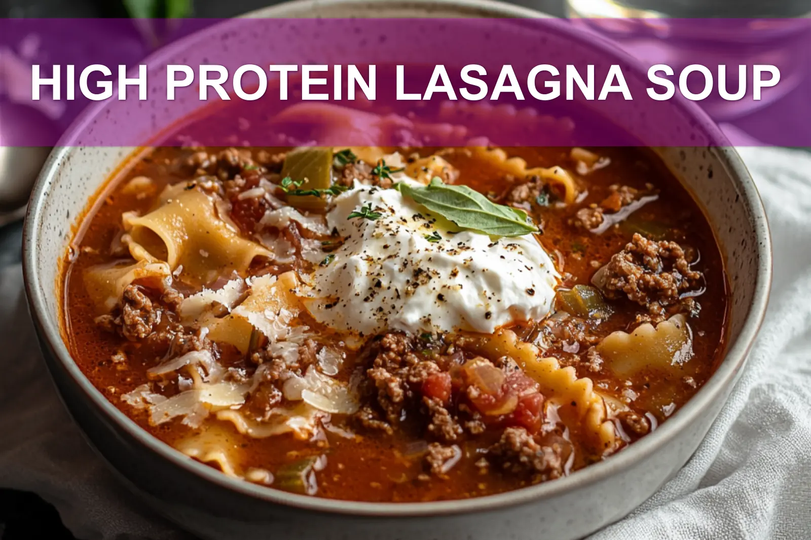 High protein lasagna soup with melted cheese and herbs in a bowl