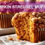 PUMPKIN STREUSEL MUFFINS on white cloth with clear glass of water warm light