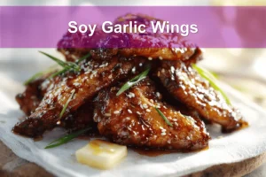 Soy Garlic Wings plated on white napkin with sesame seeds and green onions