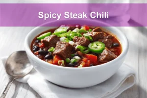 Spicy Steak Chili in bowl on white napkin warm inviting natural light glass of water
