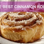 THE BEST CINNAMON ROLLS warm glazed pastries on white cloth with glass of water