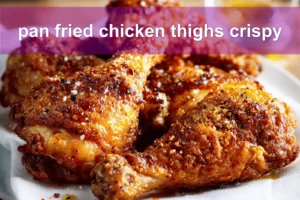 pan fried chicken thighs crispy golden skin on white cloth with simple glass of water