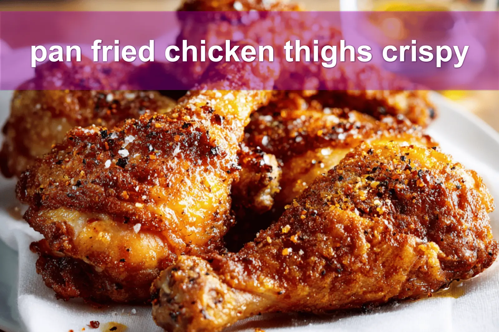 pan fried chicken thighs crispy golden skin on white cloth with simple glass of water