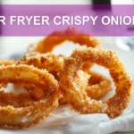 AIR FRYER CRISPY ONIONS golden onion rings on white napkin with clear glass of water