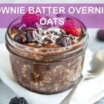 BROWNIE BATTER OVERNIGHT OATS creamy chocolate oats topped with berries dates dark chocolate and coconut flakes