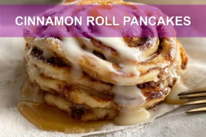Cinnamon Roll Pancakes: Delicious Easy Recipe to Love CINNAMON ROLL PANCAKES stacked with maple syrup and delicate white cheese glaze on white cloth