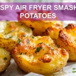 CRISPY AIR FRYER SMASHED POTATOES on white napkin with herbs and golden crisp edges