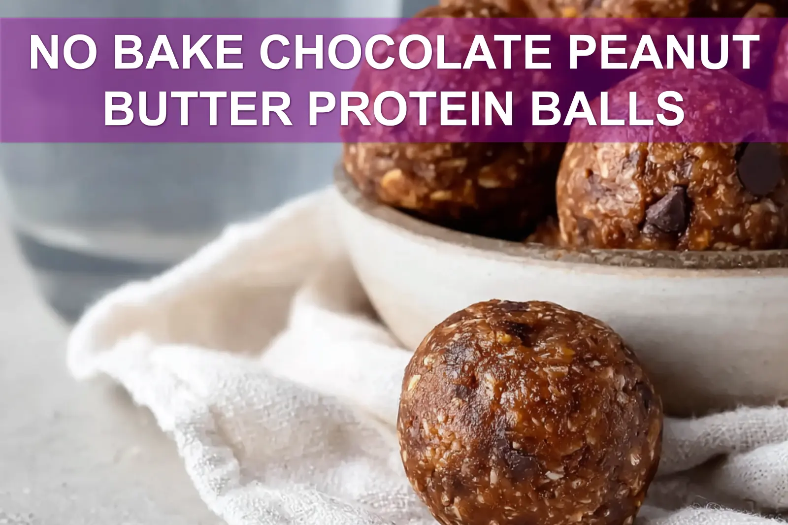 NO BAKE CHOCOLATE PEANUT BUTTER PROTEIN BALLS on wooden board with cloth and glass water