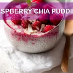 RASPBERRY CHIA PUDDING topped with raspberries sliced almonds coconut flakes maple syrup and mint