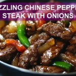 SIZZLING CHINESE PEPPER STEAK WITH ONIONS served with steamed rice green onions vibrant peppers