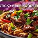 STICKY BEEF NOODLES close-up plated with sesame and green onions, warm natural light