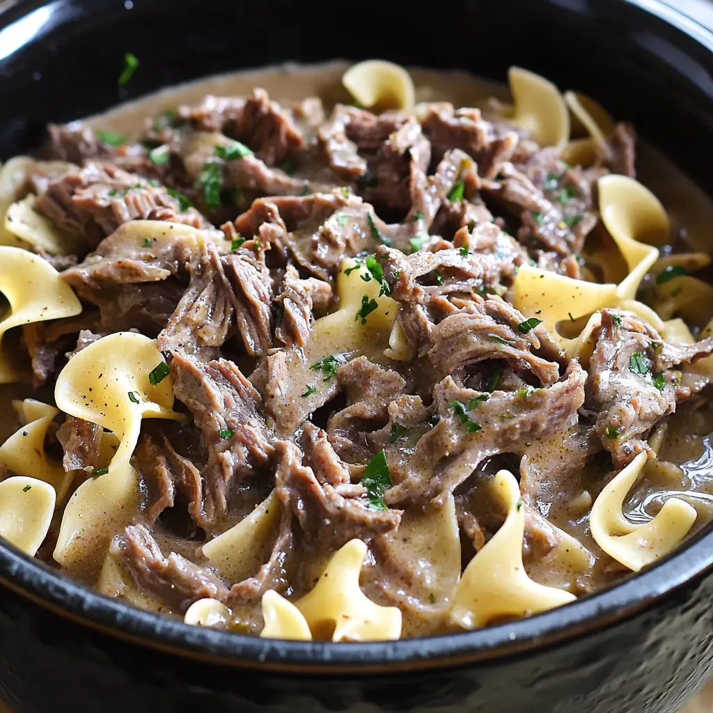 Crock Pot Beef and Noodles in a deep bowl with tender meat and wide egg noodles in rich gravy